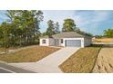 A well-designed house featuring a driveway, a blue garage door and front door, and natural surroundings at 709 Marion Oaks Mnr, Ocala, FL 34473