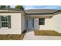 Close-up showcasing the home's entrance with a light blue front door, black shutters, and neutral-colored exterior at 709 Marion Oaks Mnr, Ocala, FL 34473