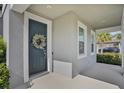 Inviting front door with decorative wreath, complemented by sidelight windows and a covered porch at 840 Livestock Loop, St Cloud, FL 34771