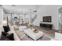Open-concept living room featuring a modern design, staircase and seamlessly connected kitchen at 840 Livestock Loop, St Cloud, FL 34771