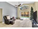 Bright living room with tile flooring, a ceiling fan, and sliding doors leading to a pool area at 1019 Lake Berkley Dr, Kissimmee, FL 34746