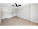 Clean bedroom featuring wood-look floors, ceiling fan, closet and a door to another room at 105 E Magnolia St, Davenport, FL 33837