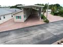 Exterior shot of home with covered carport, featuring a brick driveway and manicured landscaping at 1115 Deer Creek Blvd, Davenport, FL 33837