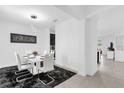 Bright dining room featuring a modern white table and stylish seating on a dark rug at 1156 Cavender Creek Rd, Minneola, FL 34715