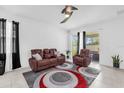 Cozy living room with reclining sofa, a patterned rug and a sliding glass door at 1156 Cavender Creek Rd, Minneola, FL 34715