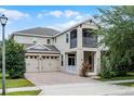 Exterior view of a two-story home with a balcony, two-car garage, and manicured landscaping at 11837 Cave Run Ave, Windermere, FL 34786