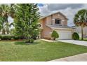 Beautiful two-story home boasts mature trees, manicured lawn, and a convenient two-car garage at 14332 Grassy Cove Cir, Orlando, FL 32824
