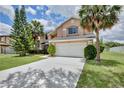 Inviting two-story home showcasing lush landscaping, a well-manicured lawn, and a convenient two-car garage at 14332 Grassy Cove Cir, Orlando, FL 32824