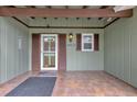 Inviting covered front porch with tile flooring, green wood, and a screen door entry at 14402 Sw 34Th Terrace Rd, Ocala, FL 34473