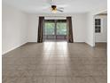 Spacious living room with tile flooring, sliding glass doors, and neutral wall color at 14402 Sw 34Th Terrace Rd, Ocala, FL 34473