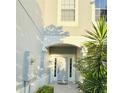 Inviting front entrance with a light-colored door, decorative trim, and lush tropical landscaping at 15258 Windmill Harbor Ct, Orlando, FL 32828
