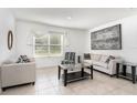 Bright living room with neutral decor, tile flooring, and a large window at 1864 Green Dragon Dr, St Cloud, FL 34771
