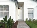 Close-up of the front door with sidelight and decorative landscaping, creating an inviting entrance at 2118 Donegan Pl, Orlando, FL 32826