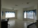 Bright living room featuring tile flooring and large windows dressed with valances and mini blinds at 2406 Grand Central Pkwy # 14, Orlando, FL 32839