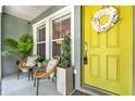 Inviting front porch featuring a yellow front door, seating and decorative plants at 2563 Breezy Meadow Rd, Apopka, FL 32712