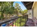Balcony view overlooking a street with mature trees and a parking area at 3946 Versailles Dr # 3946B, Orlando, FL 32808