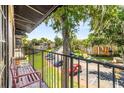 Overlooking a street with parked cars and mature trees, this balcony has a pink bench at 3946 Versailles Dr # 3946B, Orlando, FL 32808