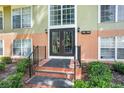 The condominium building entrance features brick steps and a black wrought-iron railing at 3946 Versailles Dr # 3946B, Orlando, FL 32808