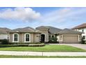 Attractive single-story home with a tile roof, lush green lawn, and a well-maintained landscape under a bright sky at 3995 Equine Cv, Lake Mary, FL 32746