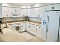 Bright kitchen with all-white cabinetry, countertops, and appliances at 4628 Harbour Village Blvd # 2308, Ponce Inlet, FL 32127