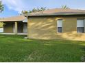 Back of the home showing the covered patio area and simple landscaping at 4871 Fells Cove Ave, Kissimmee, FL 34744