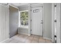 Bright entryway featuring a white door with decorative glass, neutral tile flooring, and fresh white walls at 516 Tybee Pl, Orlando, FL 32829