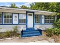Inviting front entrance featuring blue-painted steps and trim, bright white siding, and a classic white door at 516 Tybee Pl, Orlando, FL 32829