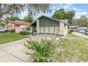 Landscaped front yard of single Gathering home with two-car garage, driveway, and blooming bush at 5308 Pinebury Ct, Orlando, FL 32808