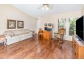 Comfortable living room with wood floors, sofa, desk, rocking chair, and bright windows at 5308 Pinebury Ct, Orlando, FL 32808