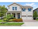 Charming two-story home features a manicured lawn, brick driveway, and a two-car garage at 9068 Sonoma Coast Dr, Winter Garden, FL 34787