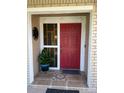 Inviting front entrance with a vibrant red door, decorative accents, and tiled landing with matching welcome mat at 1025 Sullivan St, Deltona, FL 32725