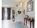 Bright foyer with tile flooring, decorated white door and tasteful decor at 1021 Jaybee Ave, Davenport, FL 33897