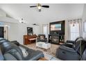 Cozy living room with a fireplace, plush seating, and a ceiling fan for added comfort at 1061 Providence Ln, Oviedo, FL 32765