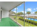 A screened-in balcony with lake views overlooking a pool and manicured lawns at 1100 S Orlando Ave # 206, Maitland, FL 32751
