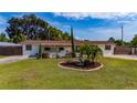 Single-story home showcasing a lush front lawn, mature trees, and decorative fountain feature at 1105 Arrowsmith Ave, Orlando, FL 32809