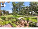 View of manicured front lawn from balcony with decorative wrought iron railing and elegant brick-paved entry at 1351 N Classic Ct, Longwood, FL 32779