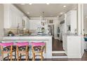 Bright kitchen featuring white cabinetry, marble countertops, a breakfast bar, and modern stainless steel appliances at 1351 N Classic Ct, Longwood, FL 32779