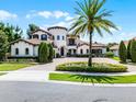 Beautiful Mediterranean-style home with mature landscaping, circular driveway, and a prominent palm tree at 1517 Edenhall Pt, Lake Mary, FL 32746