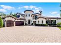 Expansive Mediterranean home featuring a three-car garage, brick driveway and elegant architectural details at 1517 Edenhall Pt, Lake Mary, FL 32746