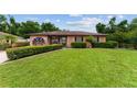 Charming home featuring a well-manicured lawn and shrubs, providing an inviting and attractive curb appeal at 316 Amanda Ln, Leesburg, FL 34748