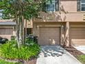 Inviting townhouse featuring a well-manicured lawn, attached garage, and neutral-toned exterior at 3599 Caruso Pl, Oviedo, FL 32765