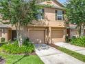 Inviting townhouse featuring a well-manicured lawn, attached garage, and neutral-toned exterior at 3599 Caruso Pl, Oviedo, FL 32765