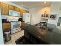 Functional kitchen boasting wooden cabinets, white appliances, and a convenient breakfast bar with granite countertop at 4002 San Gallo Dr # 105, Kissimmee, FL 34741