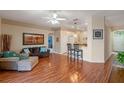 Open-concept living room with wood floors, bar seating, and view to the front entry at 5226 Smokey Water Ln, Oviedo, FL 32765