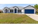 Charming single-Gathering home boasts a well-manicured lawn and a two-car garage, with a blue door, and freshly painted trim at 538 Murray St, Osteen, FL 32764