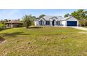 Beautiful home with blue trim and a blue garage door sits on a large lot, offering plenty of space for outdoor activities at 538 Murray St, Osteen, FL 32764