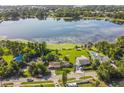 Stunning aerial view of a lakefront home, showcasing the sparkling pool, lush landscaping, and serene lake at 5527 Sandalwood Dr, Orlando, FL 32839