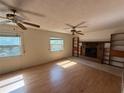 Inviting living room with wood floors, fireplace, built-in bookshelves, and lots of natural light at 5527 Sandalwood Dr, Orlando, FL 32839