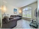 Cozy living room features wood floors, natural light, and comfortable gray couches at 5852 Stafford Springs Trl, Orlando, FL 32829