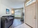 Inviting living room boasts wood floors, a large window, and comfortable gray couches at 5852 Stafford Springs Trl, Orlando, FL 32829
